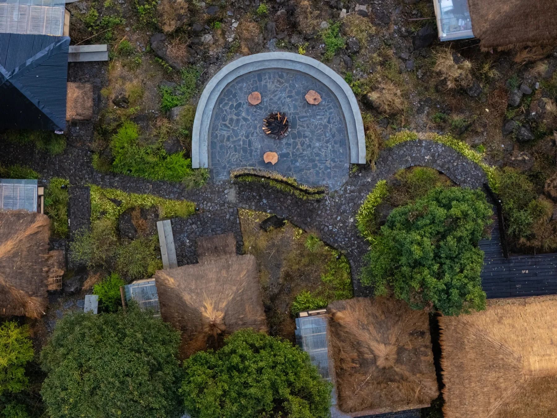 Aerial view of Kaansya — circular firepit and cottage cluster from above