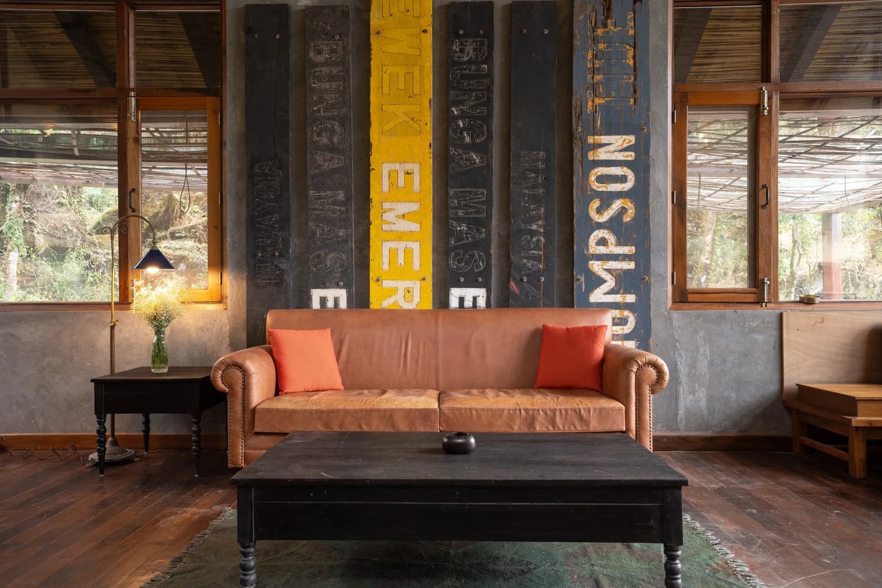 Library lounge with vintage signage backdrop and a leather chesterfield
