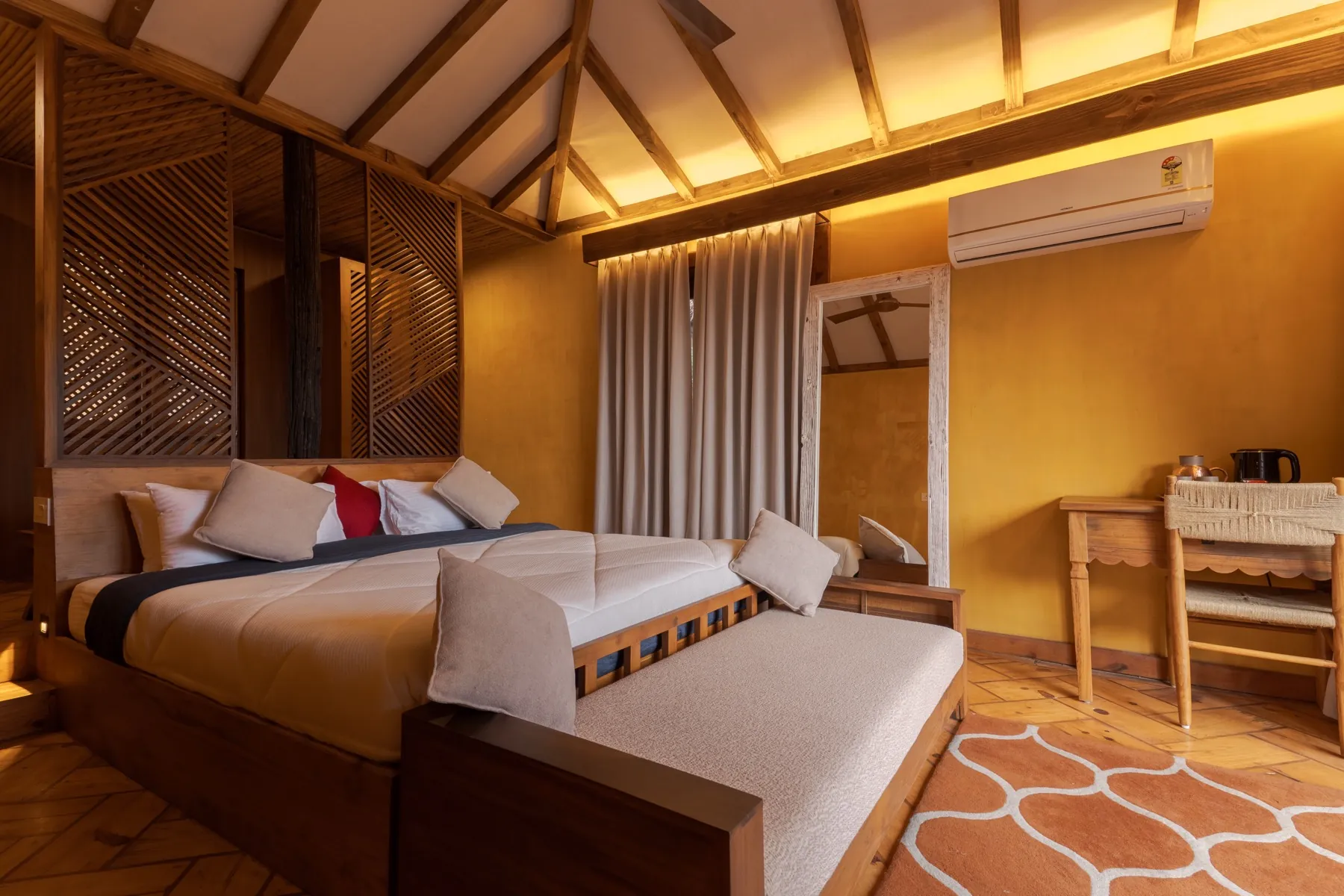 Cozy guest room corner with desk and tree-view balcony door